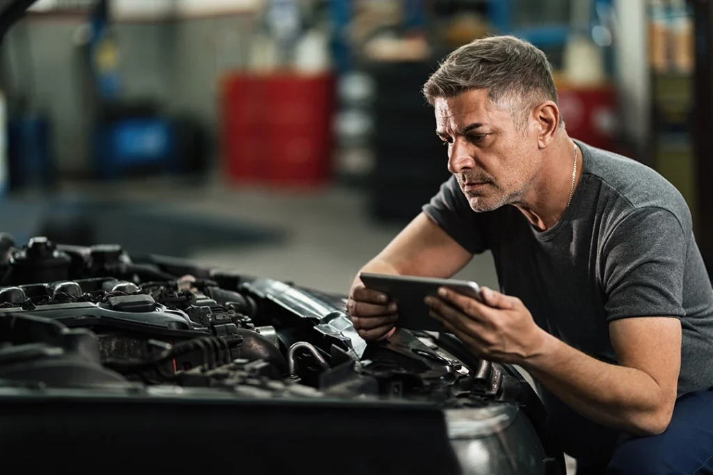 Technician doing car inspection at home Trophy Club service.