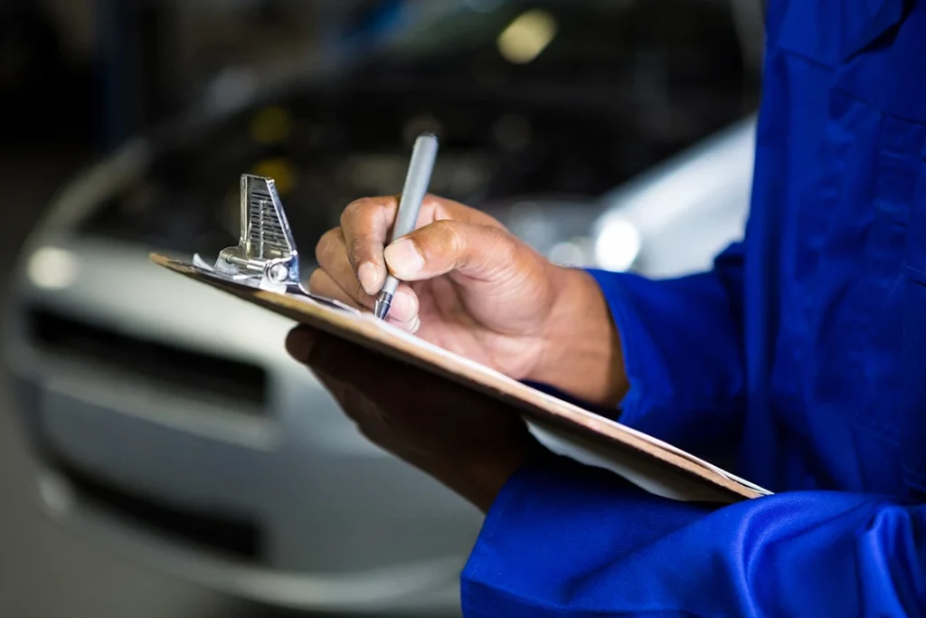 Mechanic documenting findings for car pre purchase check near North Forest