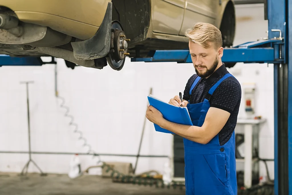 Mechanic checking vehicle in workshop during mobile auto inspection in The Estates Villages Of Gleannloch service.