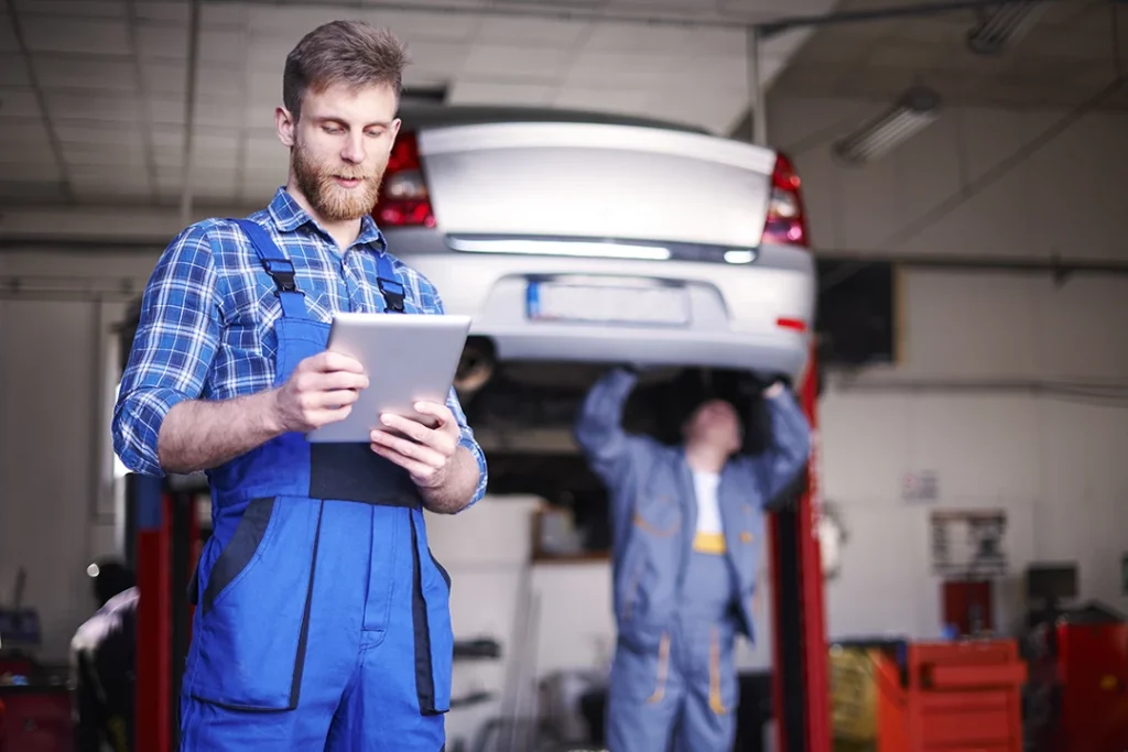 Mobile car inspection Houston in progress as technician reads inspection checklist.
