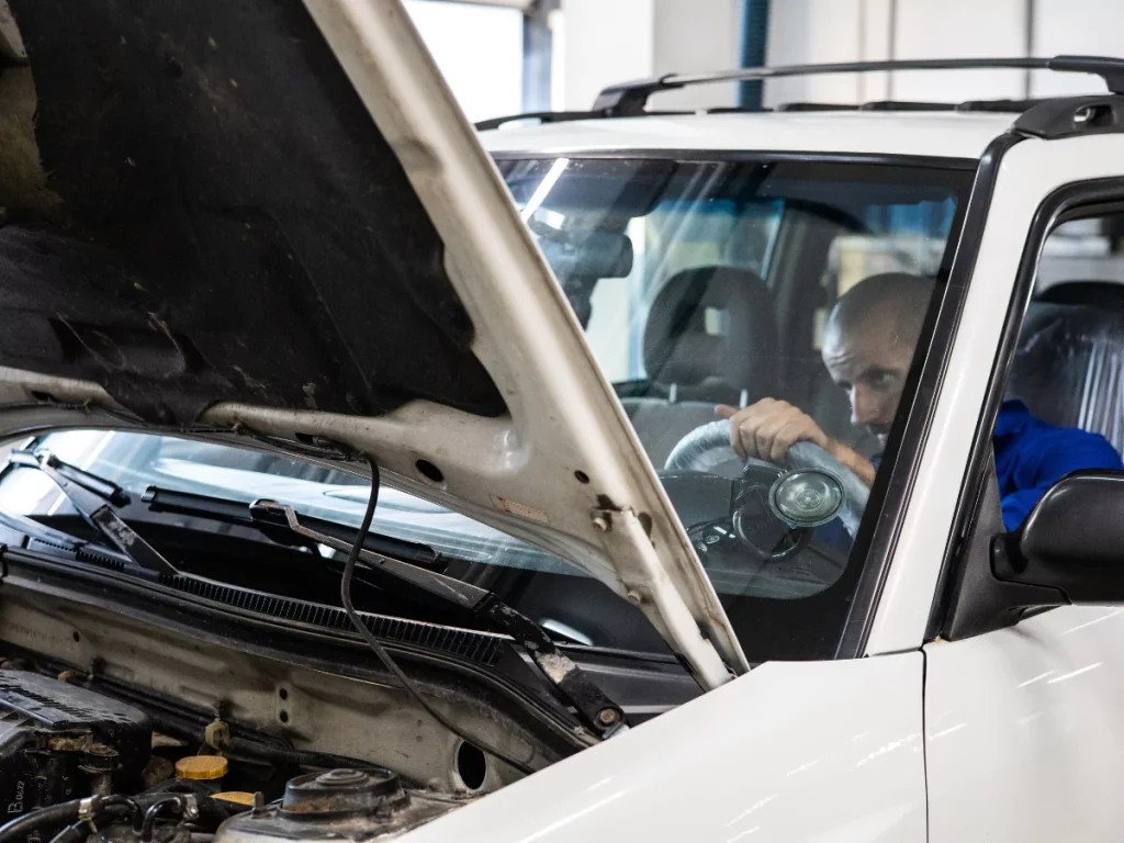 A professional performing a mobile mechanic inspection in Lakewood Place, checking the engine of a vehicle.