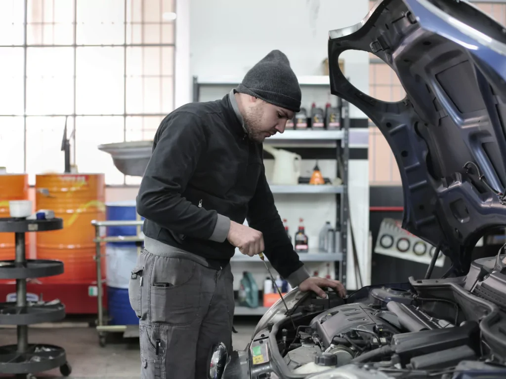 A mechanic in a garage setting, performing an inspection, emphasizing mobile re-purchase inspection in Houston.
