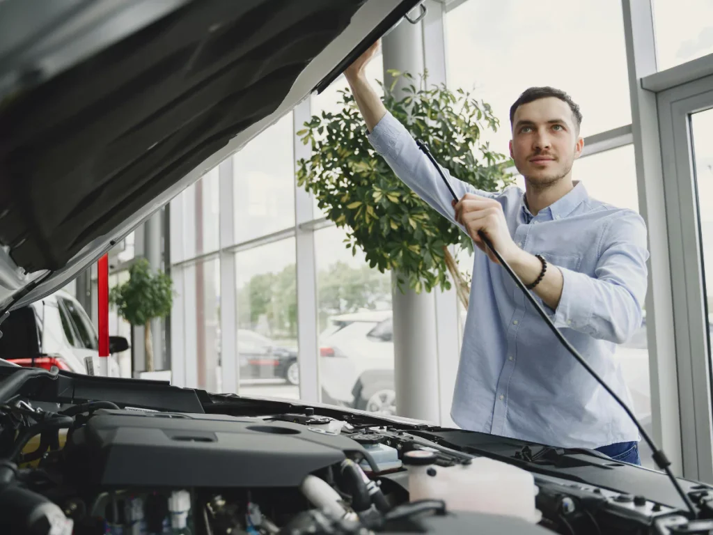 Man performing an on site car inspection at Creekside Estates South, inspecting the vehicle's engine bay.