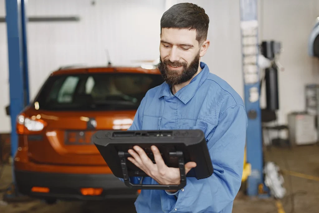 Pre purchase auto inspection houston technician looking at his notes.