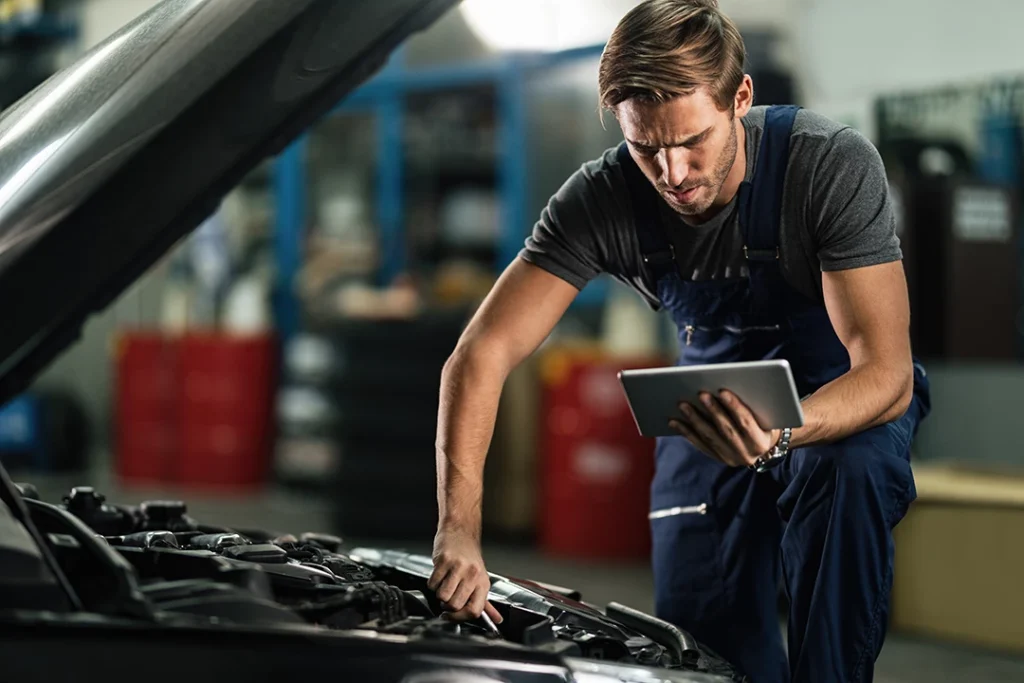 Man inspecting car with open hood pre purchase used car inspection in Houston