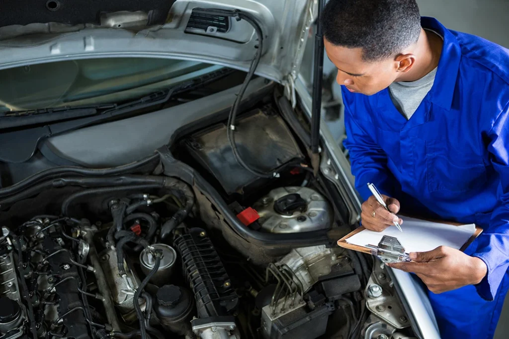 Mechanic preparing checklist during used car inspection in The Estates Villages Of Gleannloch.