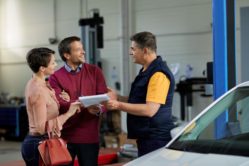 Clients discussing pre purchase inspection results with a mechanic in Houston, ensuring car quality and reliability.
