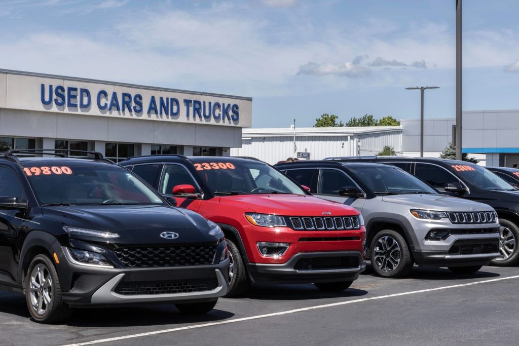 Row of used cars with prices at dealership, ideal for used car inspection services Houston.