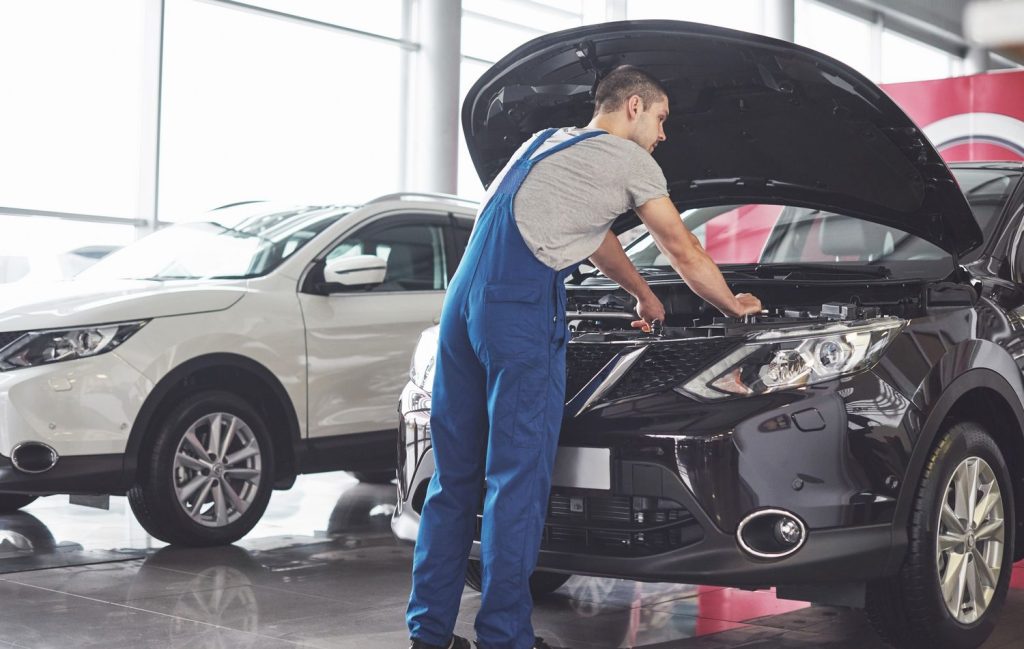 A mechanic performing third party inspection on a car in Houston, ensuring vehicle quality and safety standards.