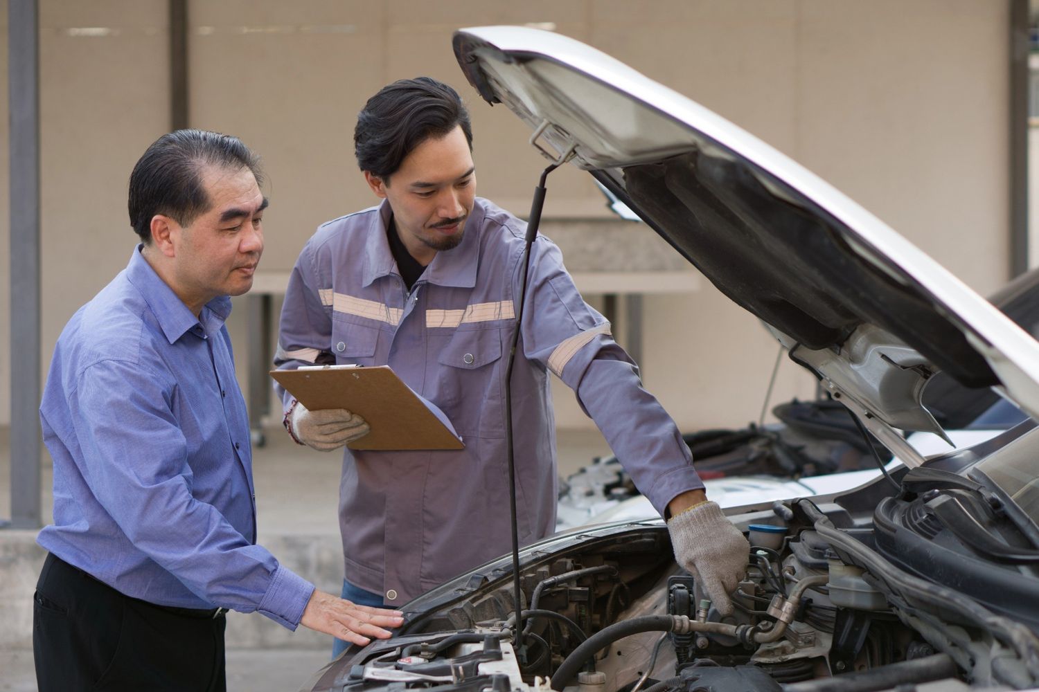 A technician explaining a pre-purchase auto inspection to a client