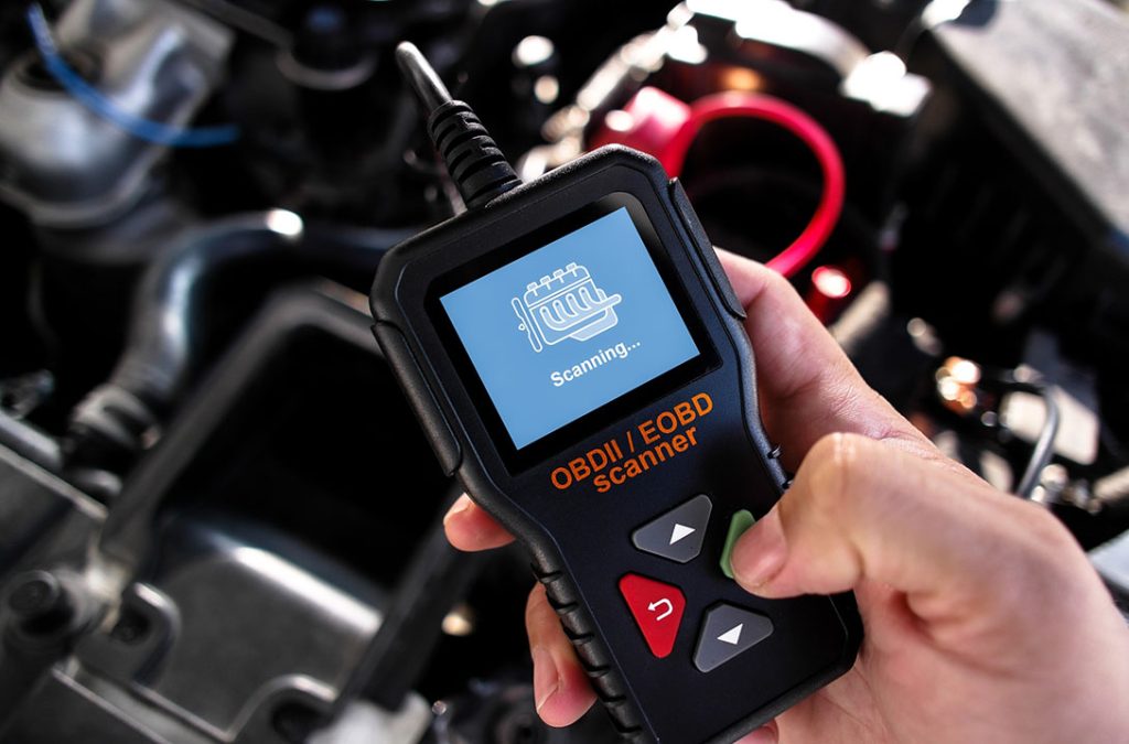 Close-up of an OBDII scanner running a diagnostic check for a professional used car inspection service.