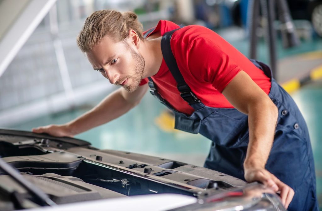 Auto mechanic performing a thorough engine check. Schedule your vehicle inspection with the best car inspection service Houston.