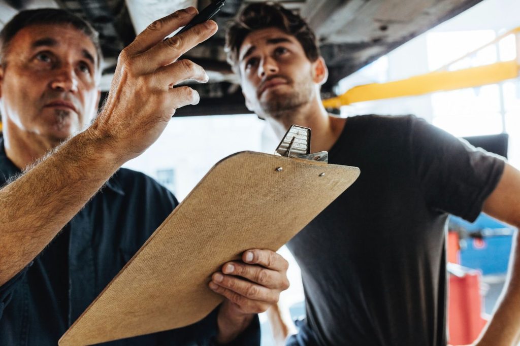 Best car inspection service Houston: Experienced mechanics reviewing a vehicle checklist and preparing for service.