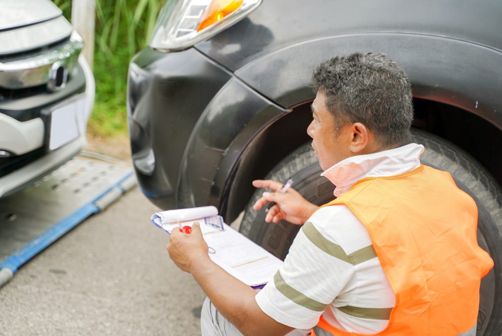 Professional inspector assessing vehicle body damage as part of a detailed certified car inspection Houston service.