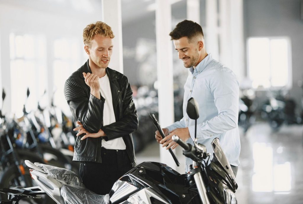 Rider receiving a pre-purchase motorcycle inspection Houston dealership consultation for a new sport bike.