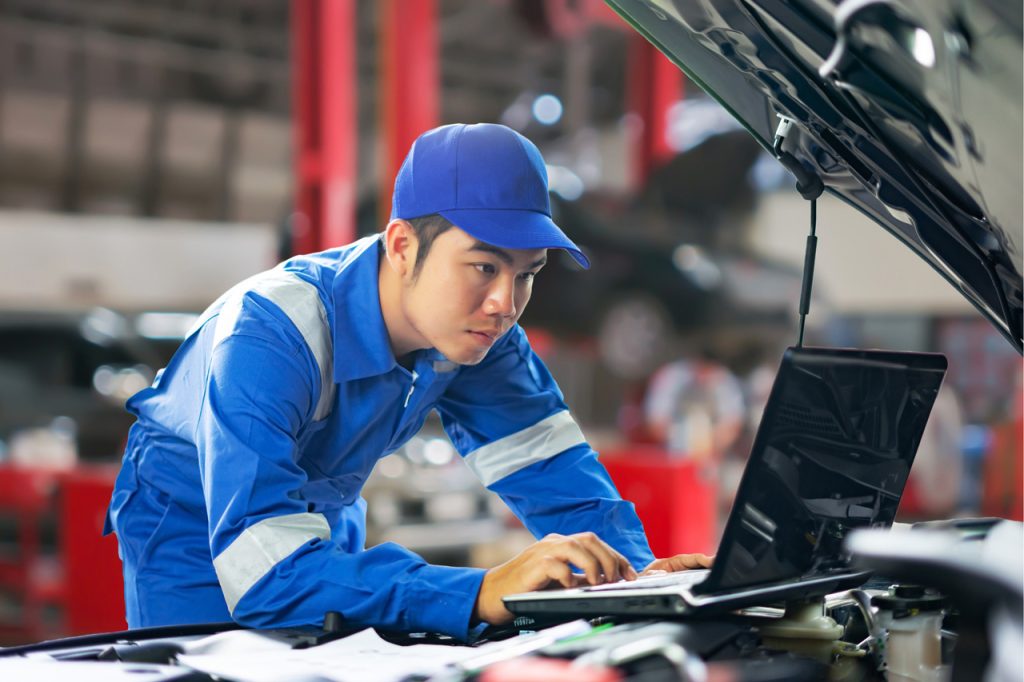 A technician performs an independent third party auto inspection using an advanced digital tablet to scan engine codes.