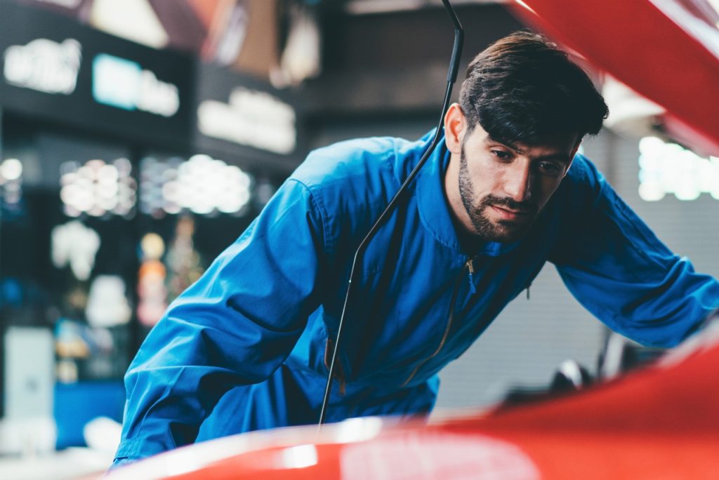 Professional mechanic performing a thorough check used car service Houston to inspect engine health for buyers.