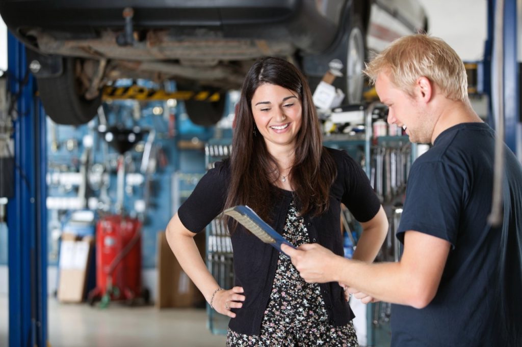 Expert mechanic showing a clean air filter to a customer at a vehicle inspection service Houston garage.