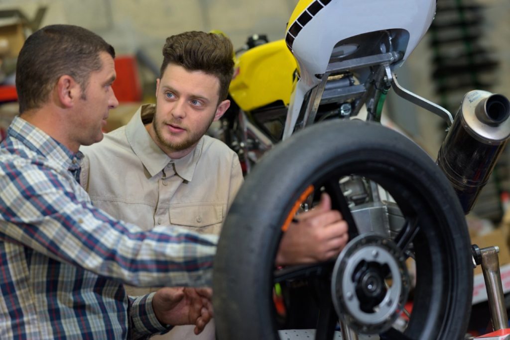 Quality motorcycle inspection Houston consultation between a specialist and client regarding wheel and tire care.