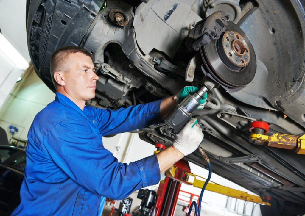 A mechanic performs critical brake service, a vital element in a professional third party inspection Houston report.