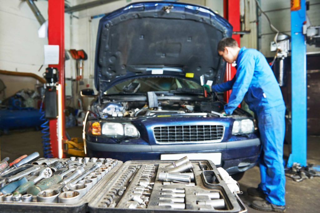 Mechanic using expert tools for a detailed automotive check, vital for a third party inspection Houston service.