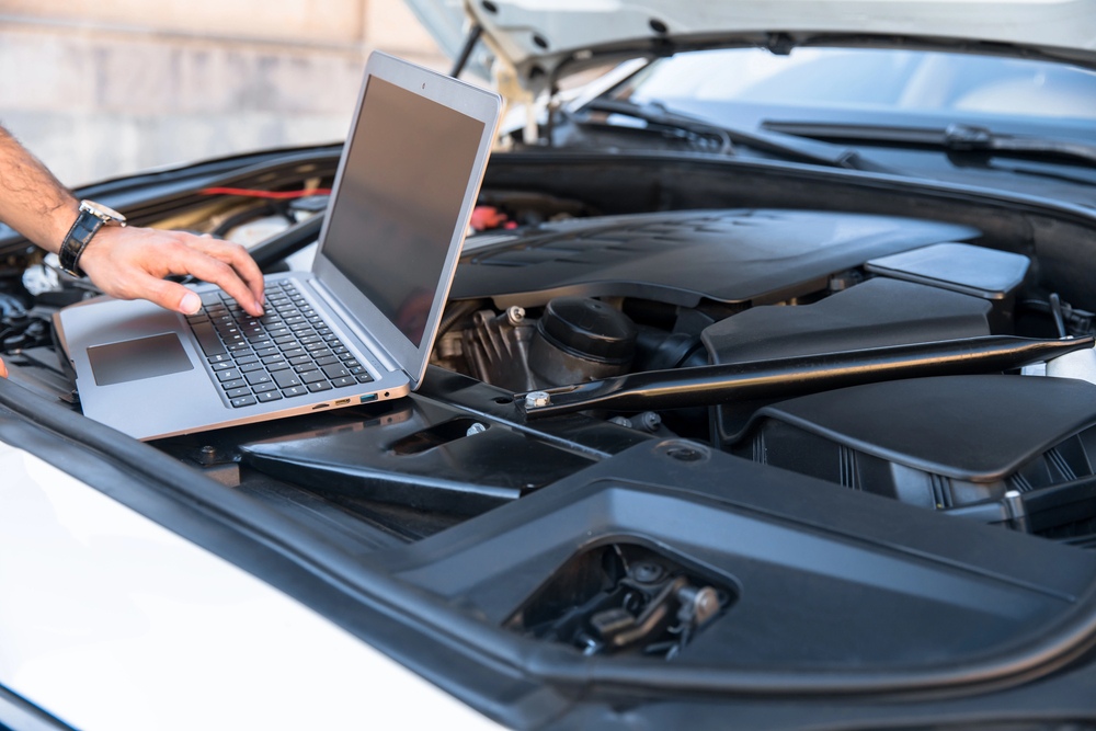 A technician performs a high-tech mobile auto inspection Houston by connecting a laptop to a vehicle's computer system.