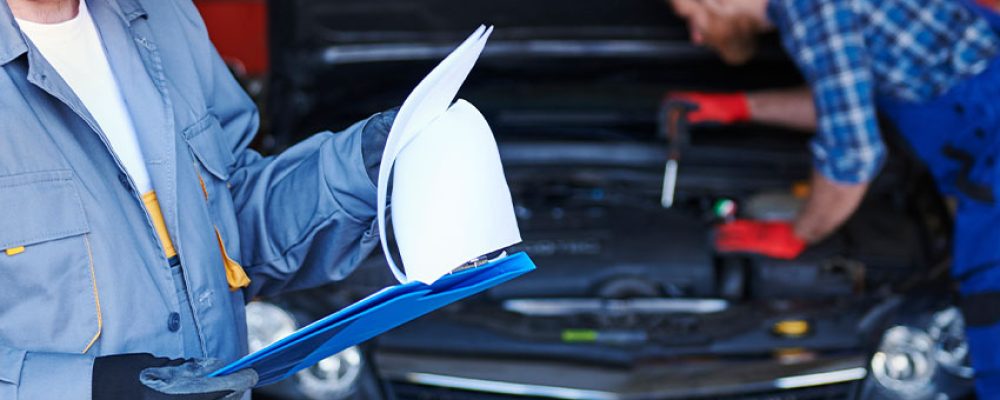 Experienced mechanic reviewing inspection checklist during BMW Inspection Houston service.